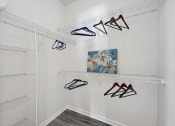 Thumbnail 9 of 26 - a closet with shoe racks and a painting on the wall