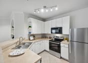 Thumbnail 2 of 26 - a modern kitchen with stainless steel appliances and white cabinets