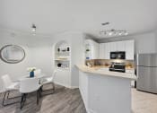 Thumbnail 1 of 26 - an open kitchen and dining area with a table and chairs and a refrigerator