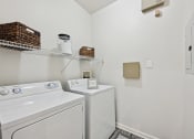 Thumbnail 10 of 26 - a white laundry room with a washer and dryer and a shelf above it