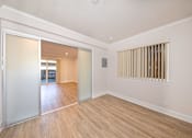 Thumbnail 14 of 27 - A room with a sliding glass door leading to a balcony.