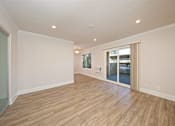 Thumbnail 16 of 27 - A room with wooden flooring and a sliding glass door.
