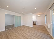 Thumbnail 12 of 27 - A room with wooden flooring and a window on the right side.