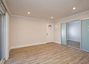 Thumbnail 13 of 27 - A room with wooden flooring and a sliding glass door.