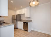 Thumbnail 15 of 27 - A kitchen with a granite countertop and stainless steel appliances.