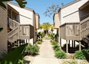 Thumbnail 2 of 27 - A row of houses with a concrete walkway between them.