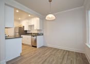 Thumbnail 26 of 27 - A kitchen with white cabinets and a wooden floor.