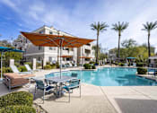 Thumbnail 4 of 39 - A pool area with a table and chairs and a sun shade.at Vintage at Scottsdale, Arizona