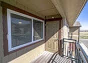 Thumbnail 19 of 22 - A balcony with a brown door and a window with blinds.