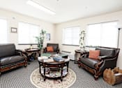 Thumbnail 17 of 22 - A living room with leather couches and a rug.