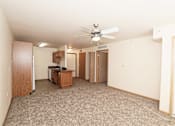 Thumbnail 16 of 22 - A room with a ceiling fan and carpeted floor.