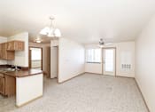 Thumbnail 15 of 22 - A spacious living area with a kitchen and a ceiling fan.