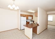 Thumbnail 13 of 22 - A kitchen area with a refrigerator, microwave, and a counter.