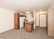 Thumbnail 5 of 22 - A kitchen area with a refrigerator, microwave, and a countertop.