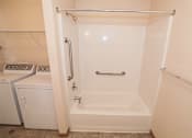 Thumbnail 9 of 22 - A white bathroom with a tub, shower, and toilet.