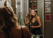 Thumbnail 12 of 26 - a woman brushing her hair in front of a mirror