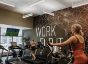 Thumbnail 21 of 26 - a woman running on a treadmill in a gym
