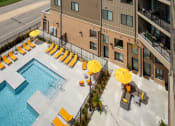 Thumbnail 24 of 26 - an aerial view of a swimming pool with yellow umbrellas and a hotel building