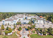 Thumbnail 1 of 32 - A large white building complex with a circular driveway in front.