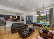 Thumbnail 2 of 22 - A modern living room with a pool table and a refrigerator.
