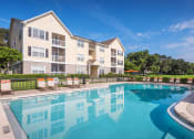 Thumbnail 5 of 23 - The Colony at Deerwood Apartments - Resort-style swimming pool with lounge area