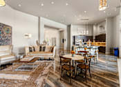 Thumbnail 5 of 32 - A modern living room with a large rug and a dining table set up.