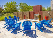 Thumbnail 6 of 23 - a group of blue chairs on a patio with a fire pit