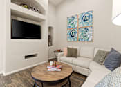Thumbnail 6 of 30 - A living room with a white couch and a wooden coffee table.