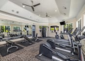 Thumbnail 6 of 22 - A gym with treadmills, elliptical machines, and other exercise equipment.