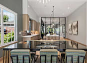 Thumbnail 6 of 30 - A modern kitchen with a glass table and chairs.