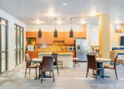 Thumbnail 7 of 26 - Centre Pointe Apartments clubhouse kitchen area with a breakfast bar and tables