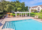 Thumbnail 7 of 23 - The Colony at Deerwood Apartments - Resort-style pool with pergola and BBQ