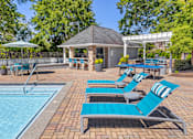Thumbnail 7 of 29 - A pool area with sun loungers and a gazebo.