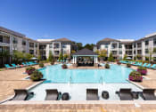 Thumbnail 8 of 19 - The Juncture Apartments resort-style pool with surrounding sundeck