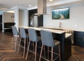 Thumbnail 8 of 22 - Resident clubhouse kitchen with fridge and bar seating - Onyx Edina