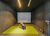 Thumbnail 9 of 32 - A person sitting on a green mat in a room with concrete walls.