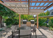 Thumbnail 10 of 25 - a patio with a pergola and a table and chairs