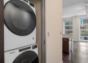 Thumbnail 12 of 36 - a washer and dryer in a laundry room with a kitchen in the background