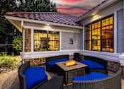 Thumbnail 11 of 22 - A patio with a table and chairs is set up outside a house.