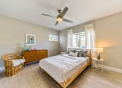 Thumbnail 13 of 14 - A bedroom with a bed, a chair, a nightstand, and a ceiling fan.