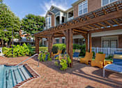 Thumbnail 13 of 28 - Pool-side lounge area with pergola coverage - Belle Harbour Apartments