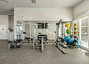 Thumbnail 13 of 32 - A spacious gym with a variety of equipment including treadmills, weights, and exercise balls.