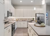 Thumbnail 14 of 21 - Arazo apartment kitchen with white cabinets