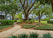 Thumbnail 15 of 25 - Well-manicured grounds with paved walkways - The Colony at Deerwood Apartments