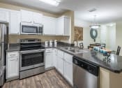 Thumbnail 15 of 23 - The Colony at Deerwood Apartments - Open kitchens with stainless steel appliances