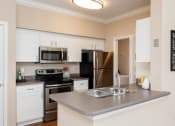 Thumbnail 15 of 18 - Weston Point Apartments - Fully-equipped kitchen with above range microwaves and refrigerators with icemakers