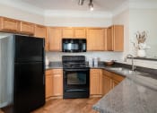 Thumbnail 16 of 21 - Carrington Place at Shoal Creek - Gourmet kitchen with black appliances
