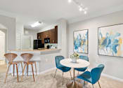 Thumbnail 16 of 22 - A dining area with a white table and blue chairs.