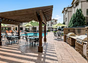Thumbnail 16 of 29 - Poolside grilling station with ample seating - First and Main Apartments