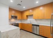 Thumbnail 18 of 36 - a kitchen with marble counter tops and wooden cabinets